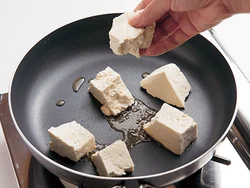 豆腐はちぎって焼きつけると、表面に凸凹ができて味がからみやすい。やさしく返しながら焼きつけて。