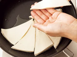 塩豆腐は三角形に切った鋭角の部分を中心にして、フライパンに放射状に並べる。