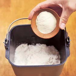 パンケースにスキムミルクを入れる。スキムミルクを混ぜるとほんのりミルクの風味が立ち、きれいな焼き色もつく。