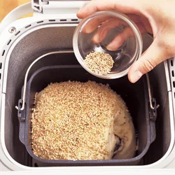 パンの上部全体に溶き卵をぬり、ごまをふる。溶き卵をぬることでごまが取れにくくなる。ごまはたっぷりふってこうばしく。