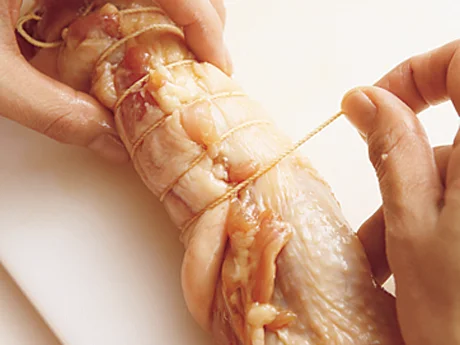 丸めたとり肉をたこ糸で巻く。たこ糸は、一方の端で1周させてからしっかり結び、全体にくるくると巻く。さらに巻き終わりもしっかり結び、ほどけないようにする。