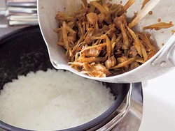 汁けを軽くきり、ご飯の上にもとをのせる。その後、鍋に残った煮汁を加えて蒸らし、味をいきわたらせて。