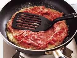 じゃがいもの生地に牛肉を広げて重ね、フライ返しで押さえながら焼くと、肉がはがれにくくなる。