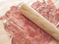 切り落とし肉を並べ、めん棒でたたいてのばし、大きな１枚にする。あらかじめ肉に片栗粉と酒をからめておくと、くっつきやすい。