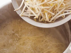 もやしで増量するのでスパゲッティは１人50g。スパゲッティがゆで上がる直前に同じ湯に加える。