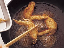 たれが煮立ったところに手羽先を加えると、味がからみやすい。