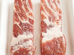 豚肉に塩をふり、すり込む。しばらくおくことで味がなじみ、日もちもよくなる。