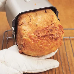 パンケースの底を片手で持ち、もう片方の手をパンに添えるようにして取り出す。パンの山をつぶさないようにして。