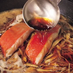 金目鯛に煮汁をかけながら煮る