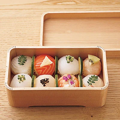 ＜箱に詰めて、春のお弁当にどうぞ＞
お弁当が入っていた木箱などに手まりずしを詰めて、手土産や近所での花見弁当に。すしとすしの間に薄切りにしたすだちをはさめば、見た目にも美しく、防腐効果も。