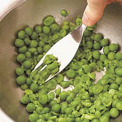 やわらかくゆでたグリーンピースはフォークなどでつぶす。好みで粗くつぶして食感を残し、調味料を加えてドレッシングにする。