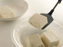 豆腐は耐熱皿に入れて電子レンジで温めることで、水きりの効果も。フライ返しで器に移し替えるとくずれにくい。