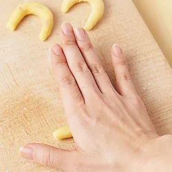 転がすときは手のひらを使うと、太さが均一の棒状になる。左右の端は少し細くしてから曲げて。