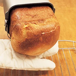パンケースの底を片手で持ち、もう片方の手をパンに添えるようにして取り出す。パンの山をつぶさないようにして。