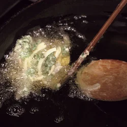 しゃもじにたねをのせてから、揚げ油に滑らせる