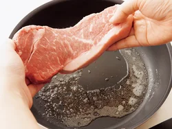 油を熱し、肉を並べ入れる。