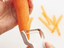 かたいにんじんを切るのも、皮むき器なら簡単！　まるのまま３cm長さ、１〜２cm幅を目安に薄く削り、残りは別の料理に使って。