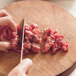 牛切り落とし肉は、大きさがばらばらなので、粗く刻み、味をしみやすくする。