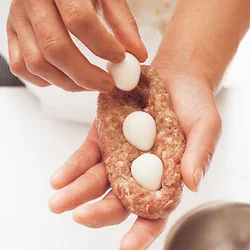 メンチだねに均等にくぼみを作ってからうずらの卵を置くと、卵が片寄らない。