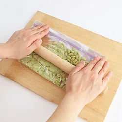 袋の上からめん棒を転がして枝豆を潰す。少し粒が残るくらいがいい。