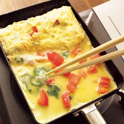 プクッとふくらんだ卵を菜箸の先で潰しながら巻くと、断面にすき間ができない。