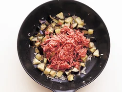 先に火が通りにくいなすを炒めてから、肉を加える。