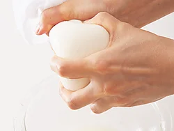 チャンプルーは豆腐の水けをしっかりきりたいので、ふきんに包んで絞る。