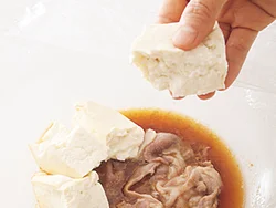 豚肉と調味料を加熱してうまみが出たところに豆腐を入れ、味をしみこませる。