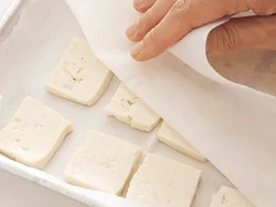 薄く切った豆腐は、上下をペーパータオルではさんで、しっかり水けをふき取る。