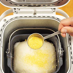 とうもろこしを粗く砕いた粉「コーンミール」を上にふることで、とうもろこしの風味がアップし、食感もよくなる。