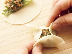 餃子の皮にしそをのせてからあんをのせて包むと、食べるときにしその香りが引き立つ。皮は四方を中央に寄せ、底が正方形になるように包む。