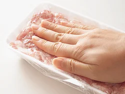トレイやバットに豚こま切れ肉を入れ、ギュッと押して肉どうしをくっつけてかたまりにする。