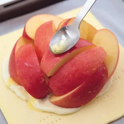 りんごにバターをぬってつやを出す。焼くとしんなりし、パイの中に沈む。