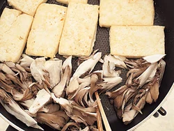 豆腐はこんがりとさせたいので、小麦粉をつけて焼く。フライパンのあいたところできのこも一緒に炒めると、効率がいい。