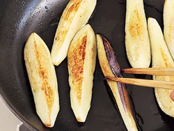 なすは食べごたえを重視。大きめの四つ割りに切るのがコツ。フライパンでこんがりと焼きつけてから耐熱皿に移して。