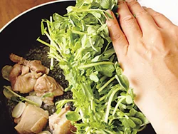豆苗はすぐ火が通るのでとり肉を焼いたあとに一度に加え、手早く炒める。