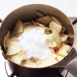 鍋にりんごを入れて、砂糖を加えて煮る。りんごは皮ごと食べるので、しっかりと皮を洗う。