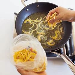 フライパンに油を入れ、玉ねぎを入れて揚げ焼きに。途中混ぜ過ぎないのが、カラリとさせるコツ。