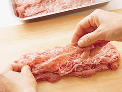 肉は１枚ずつ広げて重ねて、そのつど手で押さえて形を整えながらかたまりにする。片栗粉をからめてあるのでしっかりくっつく。