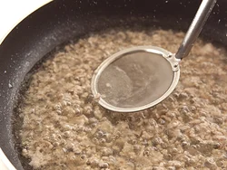 煮汁を加えて煮立ったら、肉から出たアクを取って、あんに雑味が入るのを防ぐ