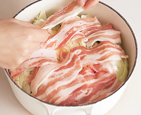 キャベツの上に豚肉を広げて蒸すと、豚肉のうまみがキャベツ全体にいきわたっておいしくなる。