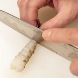 かくし包丁を入れ、ふきんで包んで身をまっすぐにする