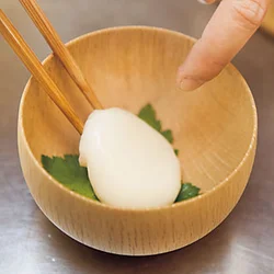 もちは、あらかじめ別の鍋でゆでてやわからかく仕上げておく。器にくっつかないように、三つ葉を敷いた上にのせて。