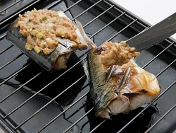 皮に焼き色がついたらねぎみそを皮目にぬり広げる。焼くことでみそのコクも出る。