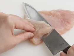 肉の中心から左右に向かって包丁をねかせて切り込みを入れ、観音開きにする