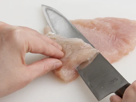 肉の中心から左右に向かって包丁をねかせて切り込みを入れ、観音開きにする