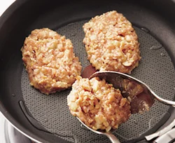 ひき割り納豆の粘りで、たねがまとまりやすい。少しやわらかめのたねなので、スプーン２つを使ってまとめて形づくり、フライパンに並べ入れる。