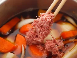 野菜を炒めて煮汁を入れ、コンビーフは軽くほぐして加える。