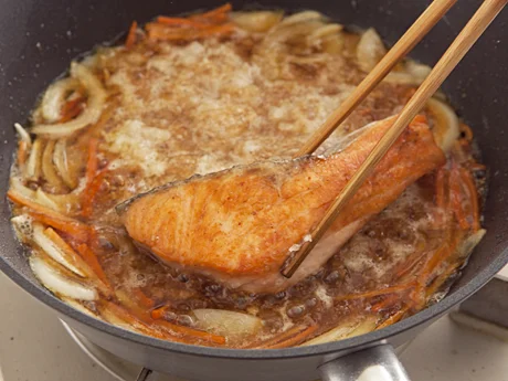 だし汁と野菜を煮立たせたところに鮭を戻し入れ、鮭に味をなじませる