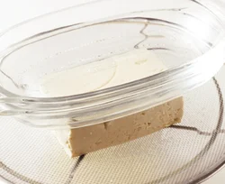 ボウルに豆腐をのせたざるを重ね、さらに豆腐の上に底の平らな皿をのせる(皿が軽い場合は２〜３枚重ねるとよい)。15〜20分そのままおく。